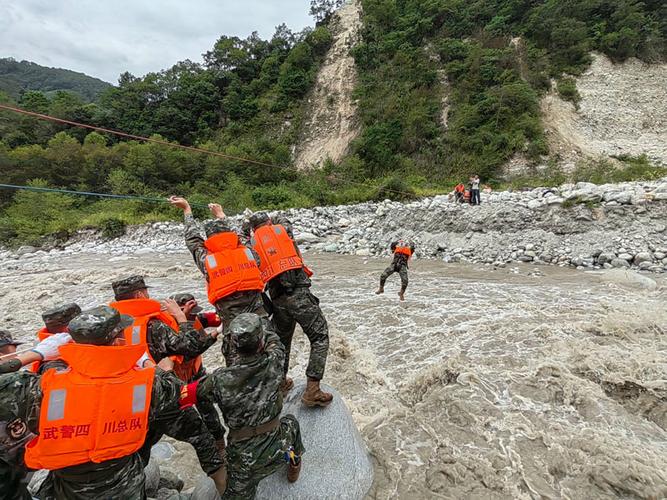 9月6日,武警四川总队甘孜支队救援官兵在泸定县磨西镇通过绳索前往河