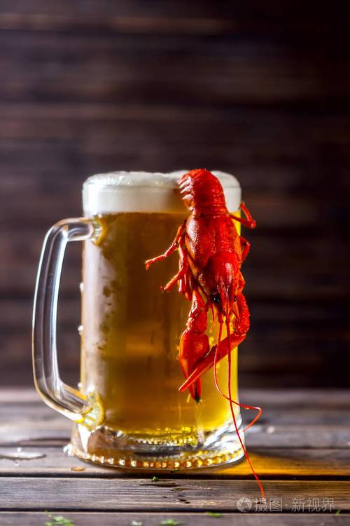 大杯啤酒和一张小木桌上的煮小龙虾照片-正版商用图片0bszkj-摄图新视