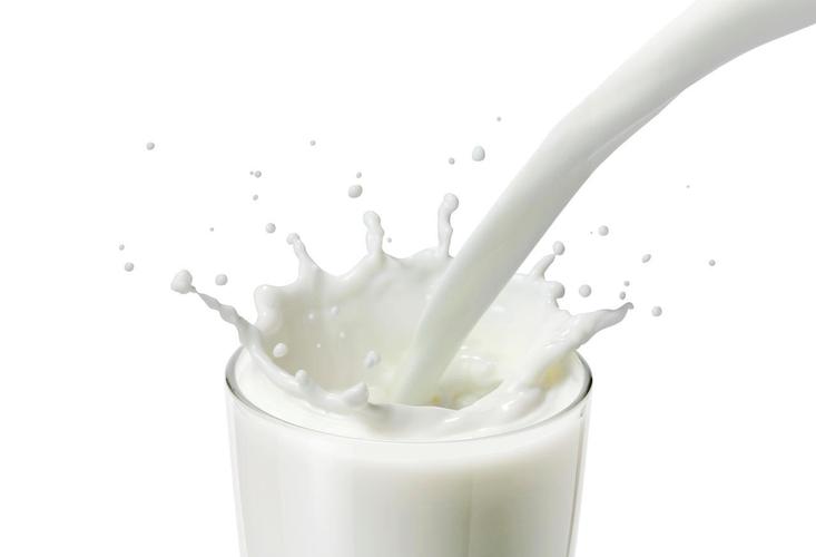 倒牛奶或一杯里的白色液体在白色背景中创建