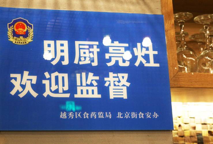 前台醒目挂着蓝色牌牌"明厨亮灶".