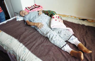 85岁的刘春玲大妈躺在床上,腿疼得不停地呻吟.