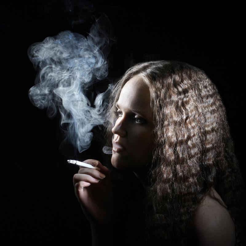 吸烟与香烟的女人,吸烟香烟烟雾在黑色背景上的女人