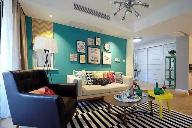 客厅的主色调是蓝,白,黑,黄,四种颜色交织,用一些彩色的抱枕打造趣味