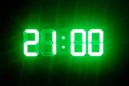 绿色发光的数字钟在黑暗中显示21:00时间照片