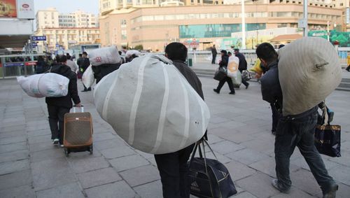 春节渐近,许多农民工携带大包小包回家过年.