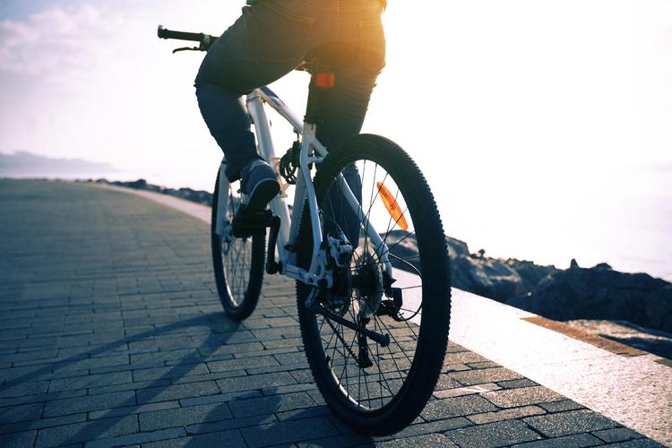 骑自行车在海边的道路上日出