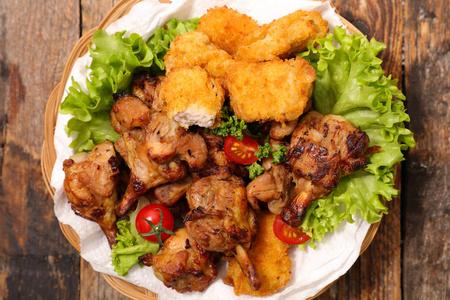 在木桌上配上新鲜绿色沙拉的炸鸡与绿色沙拉炸鸡腿沙拉/kofta 或 kof