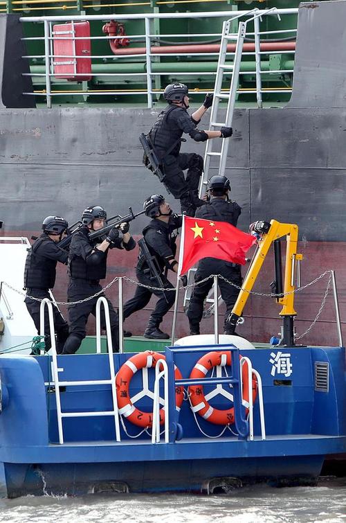 7月31日,特警队员们乘坐公安艇利用挂梯攀爬上"歹徒"藏身的船舶展开