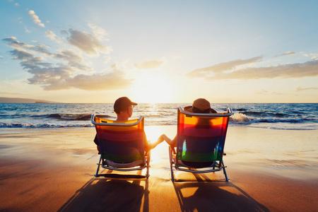 幸福浪漫的情侣在沙滩上享受美丽的夕阳照片