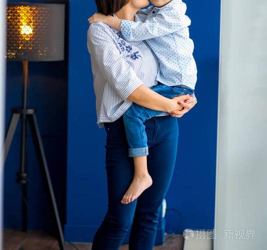 妈妈在蓝色的房间里拥抱和亲吻她的小儿子