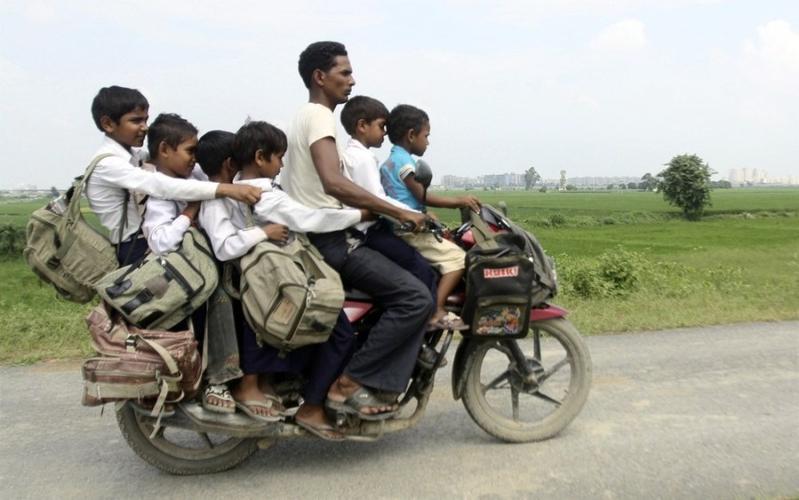 2010年9月10日,印度北方邦的大诺伊达,一名男子骑摩托驮着6名放涯的