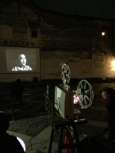露天剧场放映员用老式的放映机放映老片子《青春之歌》