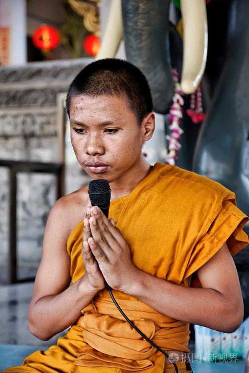 泰国.祈祷在佛教寺庙中的曼谷,一个年轻的佛教和尚