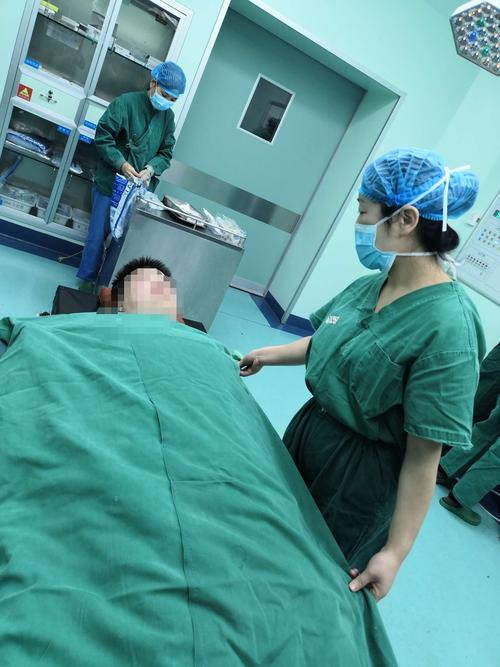 手术间里,患者躺在了铺着棉垫和体位垫的手术床上,我们为患者加盖一