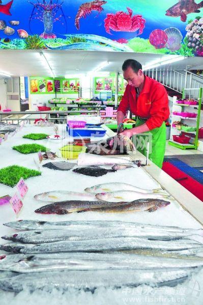 图为一海鲜超市的工作人员正在杀鱼. (杜梅钗 摄)
