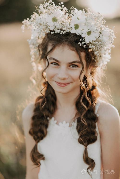一个年轻的女孩戴着一个夏天的花环头上戴着一个微笑的花环