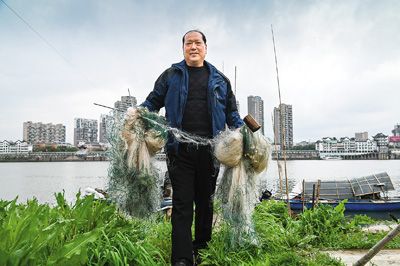 浙江省金华市兰江水域岸边,61岁渔民陈福明收起渔网上岸,开始四个月的