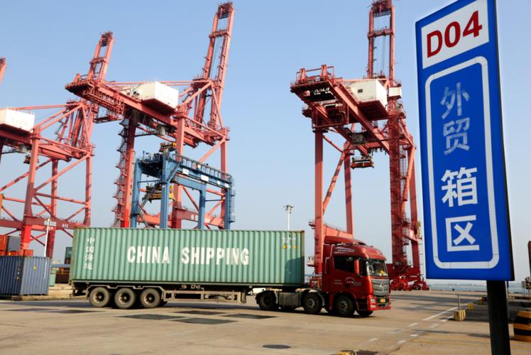 运输车辆在江苏连云港港集装箱码头转运集装箱准备装船出口国外.