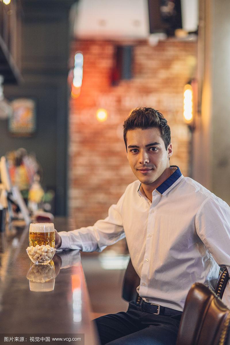 男人独自在酒吧喝啤酒的照片