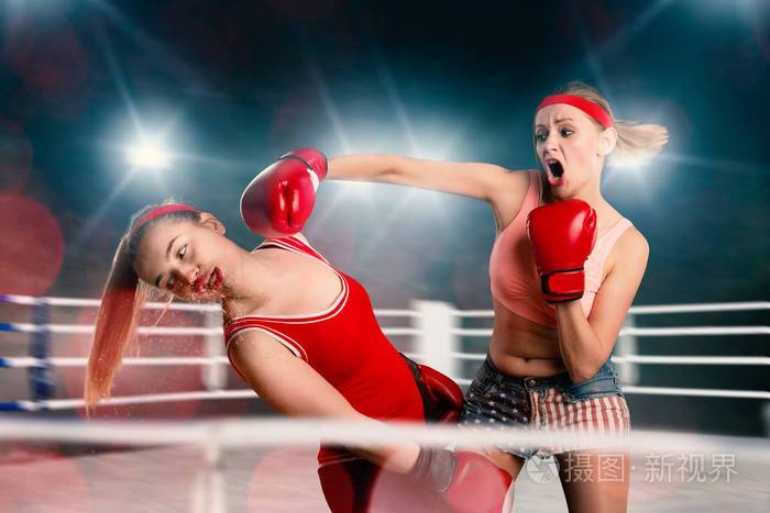 两个女kickboxers在拳击场上打架