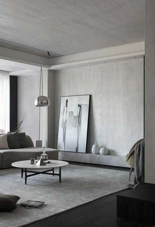 客厅在深灰色地板上铺着灰色地毯,天花与墙面也加入了浅灰色的材质