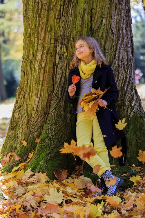 秋天的乐趣 —— 可爱的女孩,有着一段有趣在片秋色的公园