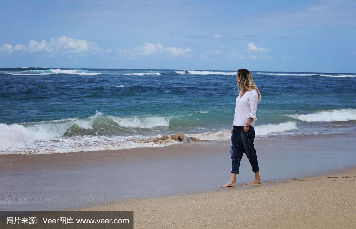 女人光着脚走在海边的夏天海滩上,暑假,自由的概念,巴厘岛,印度尼西亚