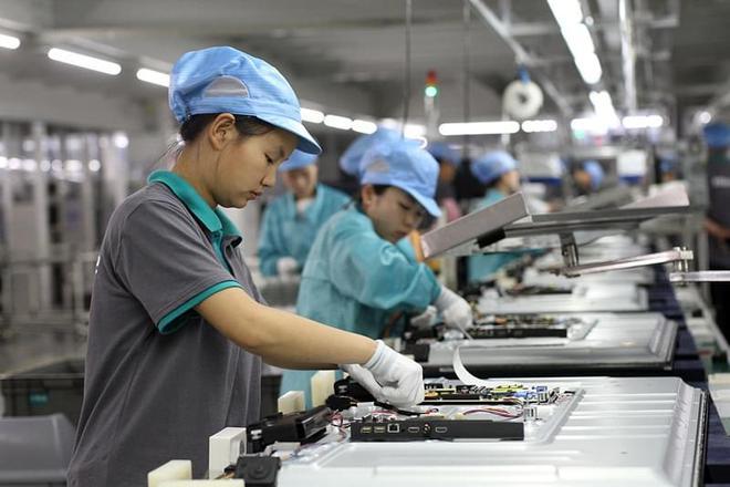 在海信集团黄岛生产基地,工人在组装生产电视机(2015年5月26日摄).