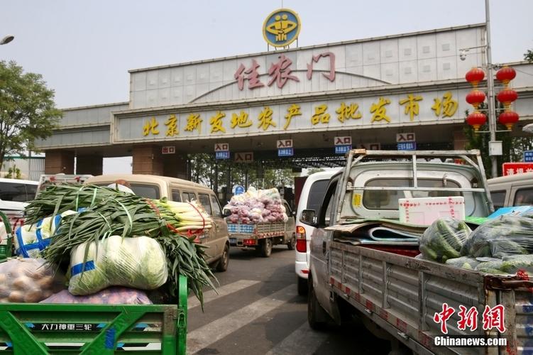 4月25日,北京新发地农产品批发市场,商户在装运蔬菜.