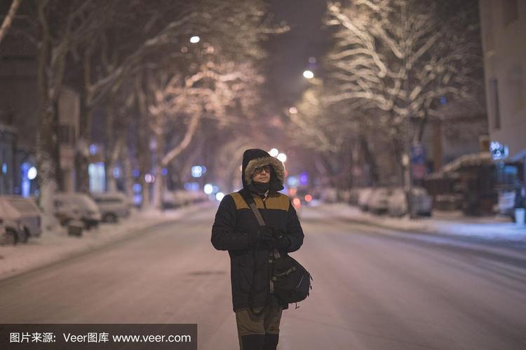 一个人走在雪夜的街道上