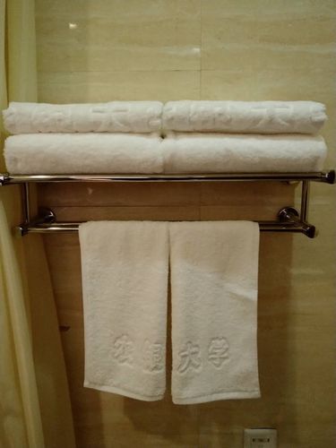 浴巾整齐叠好放在浴巾架,毛巾对折,合成"农银大学"字样面向客人.