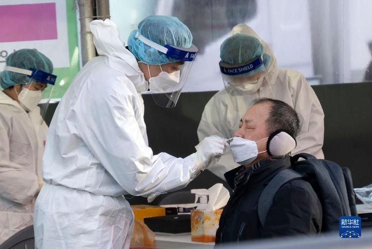 2月16日,医护人员在韩国首尔一处新冠病毒检测点为检测者采样.