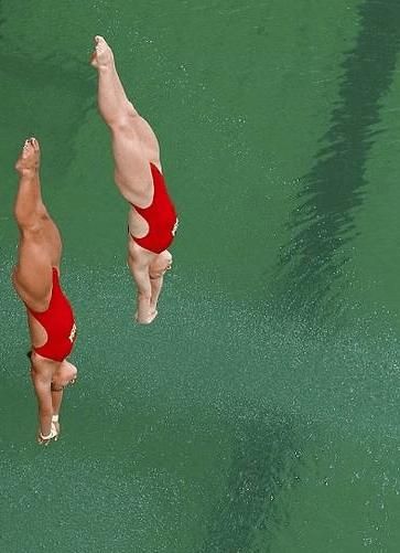 女子双人跳水比赛的情景跳水池水变成绿色,与旁边泳池形成鲜明对比