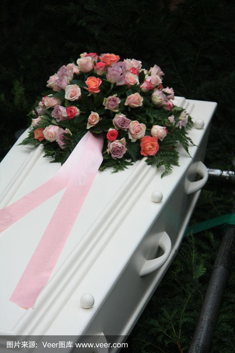 白色棺材上放着粉色的同情花