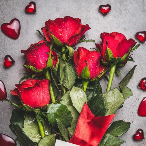 大束鲜花与红玫瑰丝带我爱你刻字卡和灰色的背景顶视图上的心