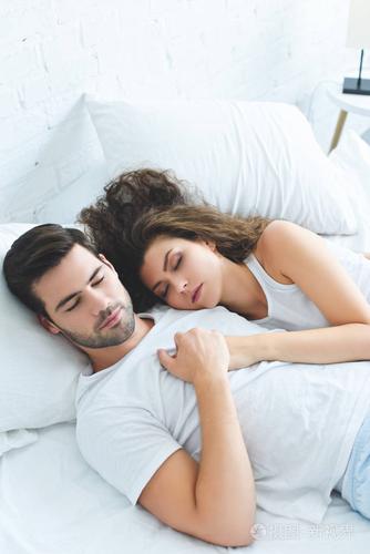 在床上睡觉时牵手的年轻夫妇的高角度视图照片-正版商用图片0srzie-摄