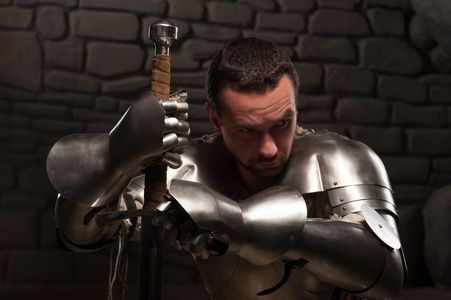 中世纪剑中世纪的骑士,跪着的剑照片
