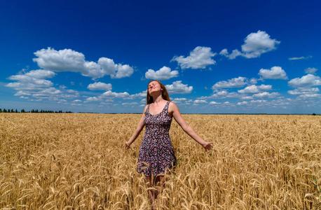自由,心灵,健康的概念. 蓝天背景下成熟麦田里的女孩照片