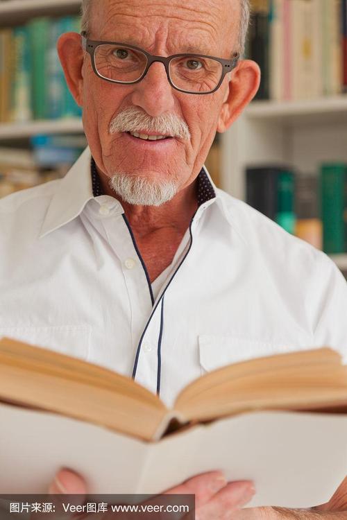 戴眼镜的老人在书柜前看书.