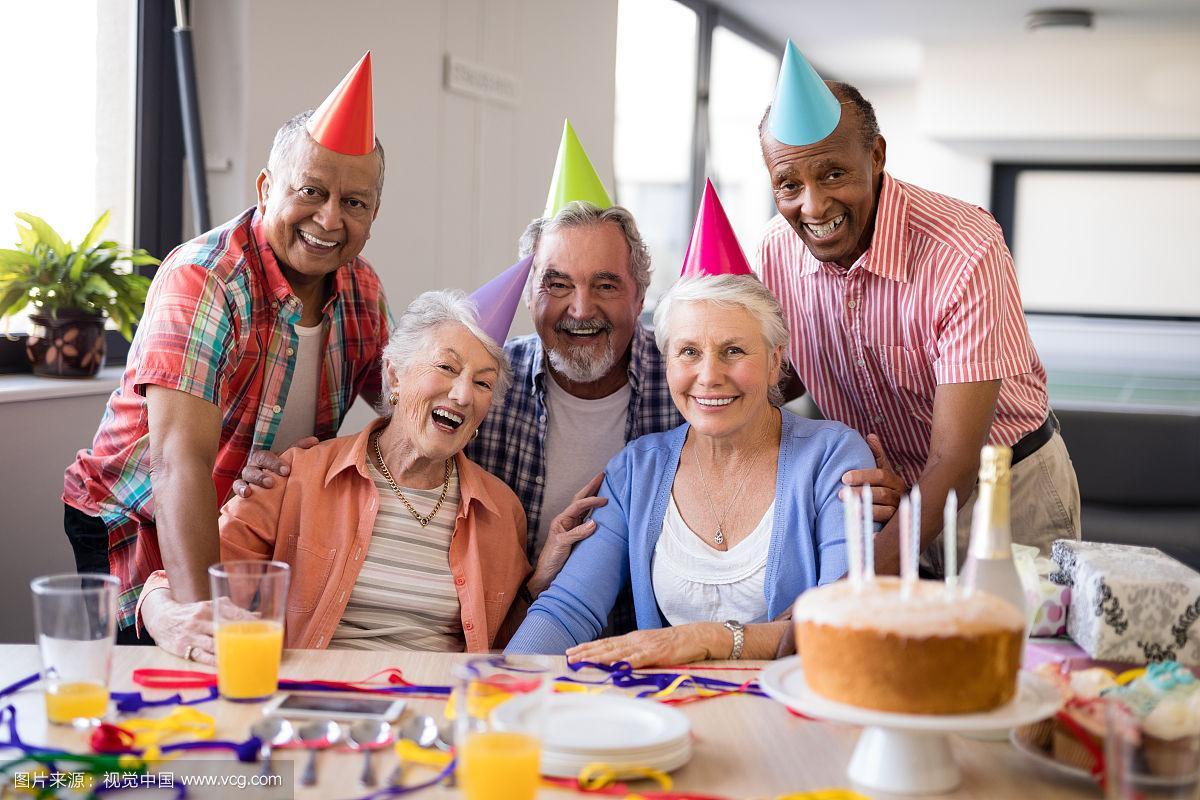 戴着派对帽的老人在敬老院庆祝生日的照片