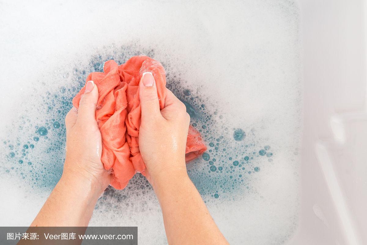 女性用手在水槽里洗颜色的衣服