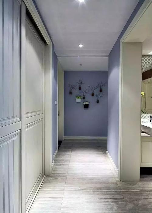 将走廊墙面装修成与其他空间一致,结合几盆装饰花点缀,既简单又方便