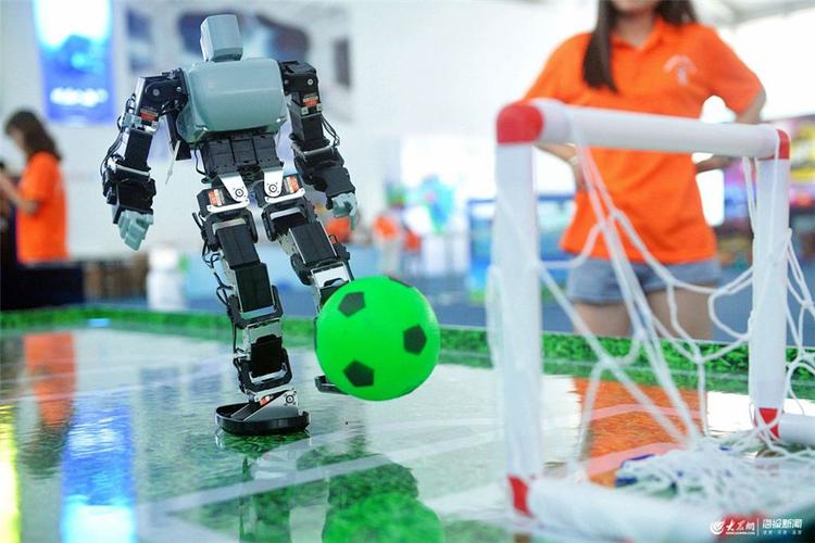 2019年7月22日,山东青岛金沙滩啤酒城,机器人在踢足球.