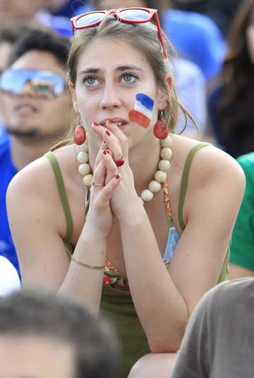 6月11日,一名法国女球迷在巴黎埃菲尔铁塔下的大屏幕前观看法国队与