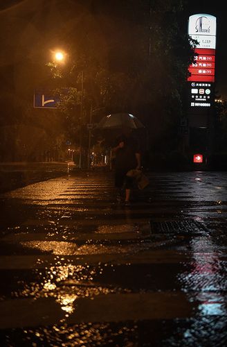 8月2日凌晨,在深圳市街头,一名行人在雨中前行.