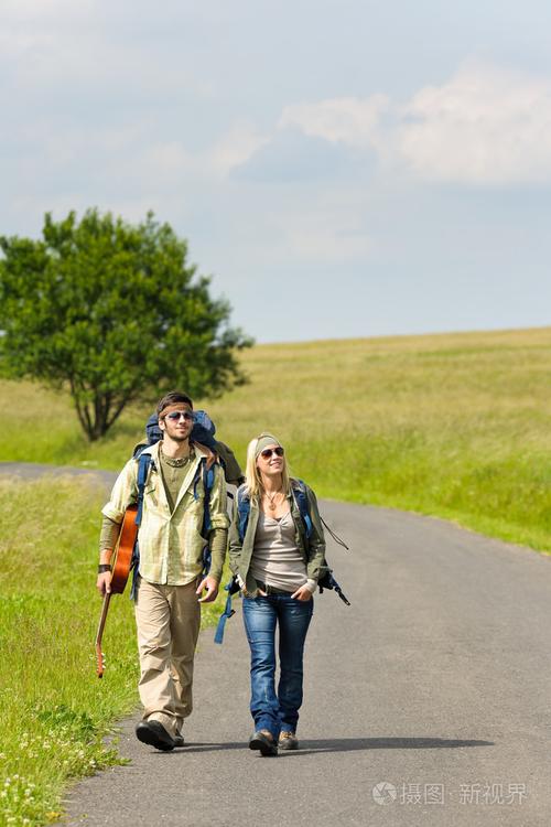 徒步旅行的年轻夫妇背包踩沥青路面照片-正版商用图片0ve2it-摄图新