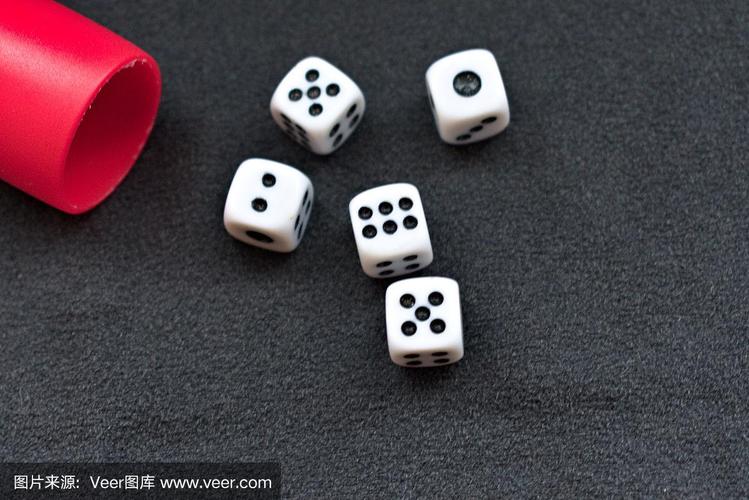 五个骰子被扔到桌子上,黑色的背景,赌博的概念形象和游戏的机会