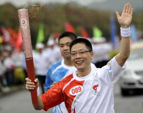 图文北京奥运圣火在汕头传递严亮持火炬表情轻松
