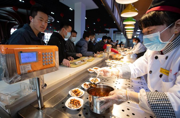2月11日,在四川大学望江校区东二食堂,工作人员为就餐师生服务.