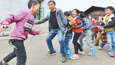 5月21日,林凯在和孩子们玩"老鹰捉小鸡"游戏.王京华摄(影像中国)